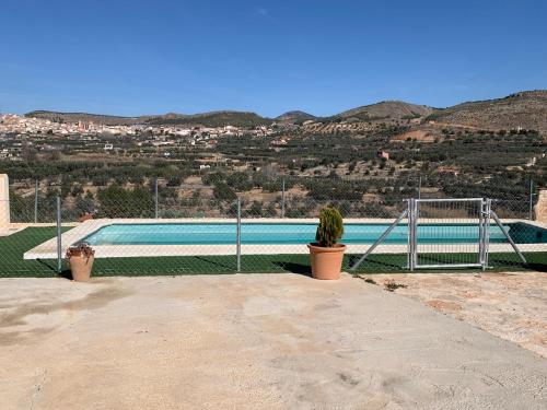 a pool with a fence and a plant next to it at Casa la Umbría in Elche de la Sierra