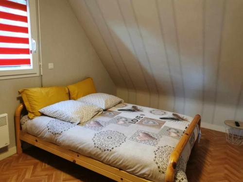 un lit avec deux oreillers dessus dans une chambre dans l'établissement A 3 min de la plage à Sarzeau, à Sarzeau