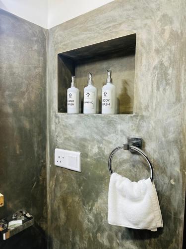 a bathroom with three bottles of soap on a shelf at La Casa Bella in Ella