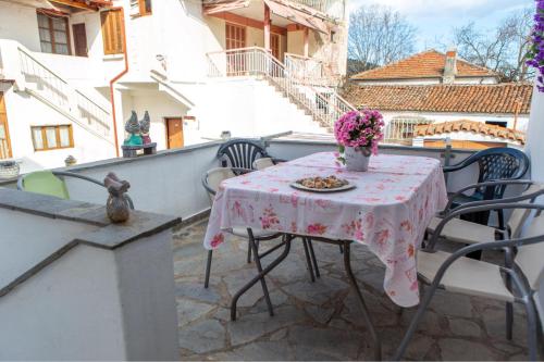 a table with a vase of flowers on a balcony at Titika House in Nea Vrasna