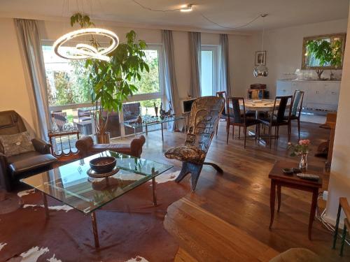 ein Wohnzimmer mit einem Tisch und einem Esszimmer in der Unterkunft Elegantes Reihenhaus, 700 m vom See, zentral, wie neu, ruhig, grün, Kinder mindestens 6 a alt   in Starnberg