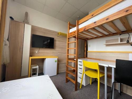 a room with a bunk bed and a table and chairs at MyHome in Modřice