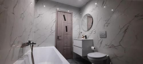a bathroom with a tub and a toilet and a sink at Casa Bellevue in Bacău