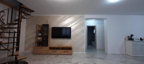 uma sala de estar com uma televisão de ecrã plano na parede em Casa Bellevue em Bacau