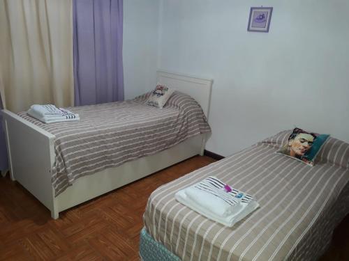 エセイサにあるFRIDA APARTMENT remis gratis a Ezeizaの女性の写真を用いたベッドルーム内のベッド2台
