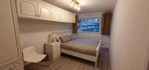 a small bedroom with a bed and a window at LONDON EXPERIENCE in Eltham
