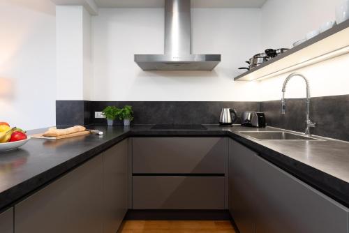 a kitchen with black counters and a sink at Two-level apart with a terrace near the Vltava River in Prague