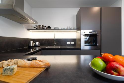 a kitchen with a bowl of fruit and a plate of bread at Two-level apart with a terrace near the Vltava River in Prague