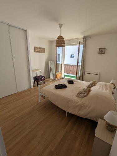 une chambre avec un grand lit et un parquet dans l'établissement Cosy et moderne avec Clim - Lac Léman, à Thonon-les-Bains