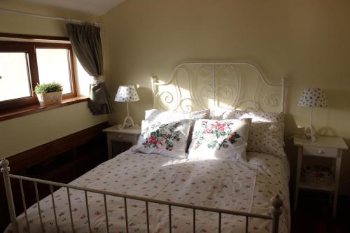 a bedroom with a white bed with flowers and pillows at Appartamento incantevole centrale e nel verde in Rivisondoli