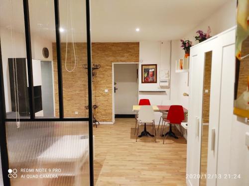 uma sala de estar com uma mesa e cadeiras vermelhas em Appartement idéal visite de Paris em Ivry-sur-Seine