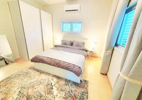 a bedroom with a bed and a rug at Super Spacious 2BD Habima TLV heart, Balcony & Parking in Tel Aviv