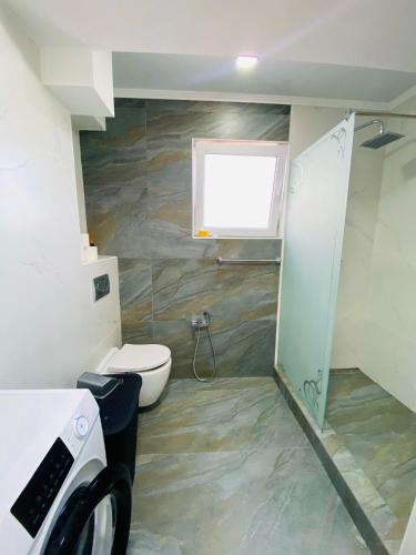 a bathroom with a toilet and a window at Apartament lux Chisinau in Chişinău