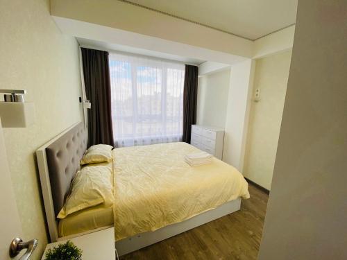 a small bedroom with a bed and a window at Apartament lux Chisinau in Chişinău