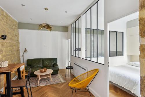 Cette chambre comprend un lit, un canapé et une table. dans l'établissement Beau 3 pièces rue Poissonnière, à Paris