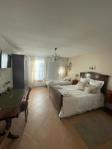 - une grande chambre avec 2 lits et un bureau dans l'établissement La porte dorée..., à Saint-Nicolas-de-la-Grave