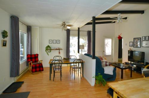 a living room with a table and a couch at Chalet Mahigan Sipy in Saint-Paulin