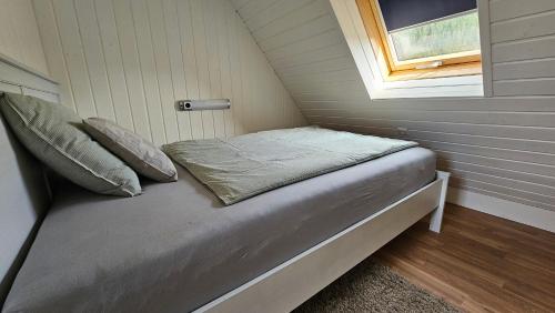 Cama en habitación pequeña con ventana en Träumerei Veitsch, en Veitsch