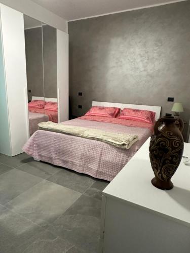 een slaapkamer met een bed met roze lakens en een spiegel bij B&B Love - HOLIDAY HOUSE- Casa Vacanza Santa Severa in Santa Severa