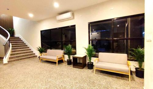 a lobby with two chairs and a staircase with plants at Rudolfo Suites in Roxas City