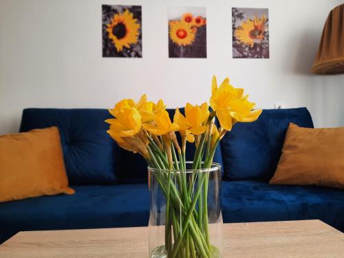un jarrón de flores amarillas sentado en una mesa en Apartament Bałtycka Sardynka en Ustka