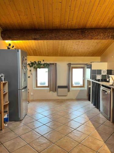 d'une cuisine équipée d'appareils en acier inoxydable et d'un plafond en bois. dans l'établissement Comme à la maison, à Elne