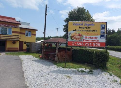 a sign for a restaurant on the side of a road at Zajazd Jagoda Pokoje i Restauracja 