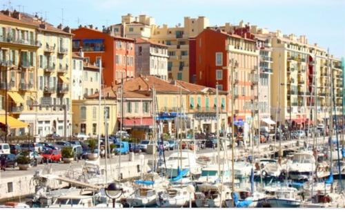 un groupe de bateaux garés dans un port avec des bâtiments dans l'établissement APPARTEMENT NICE le PORT, à Nice