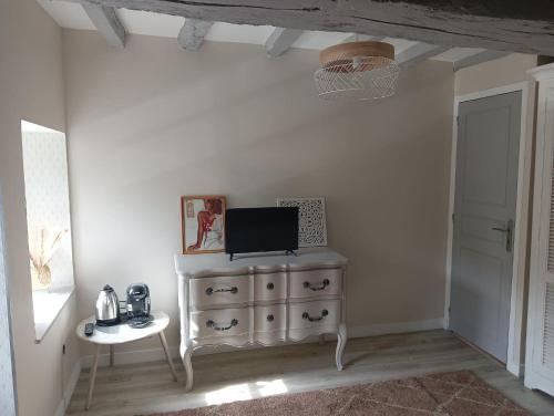 Cette chambre comprend une commode avec une télévision. dans l'établissement Chambre d'hote Familiale de la maison Bleue, à Lanvallay