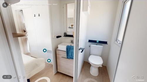 uma pequena casa de banho com WC e lavatório em Mobil Home Le Rimbaud - 4/6 pers - 2 ch - 2 sdb em Saint-Jean-de-Monts