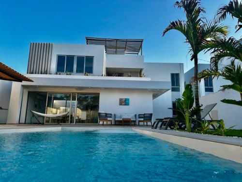 een villa met een zwembad voor een huis bij HERMOSA CABAÑA A POCOS MINUTOS DE BARRANQUILLA in Puerto Colombia