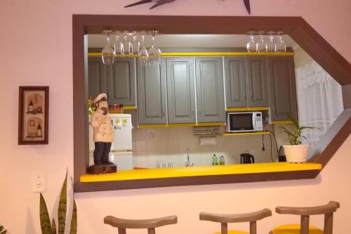 um modelo de cozinha com armários verdes e bancos em Praia, Sol, luar e lazer em Itapema