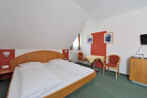 a bedroom with a bed and a table and chairs at Gasthof zum Lamm in Gomadingen