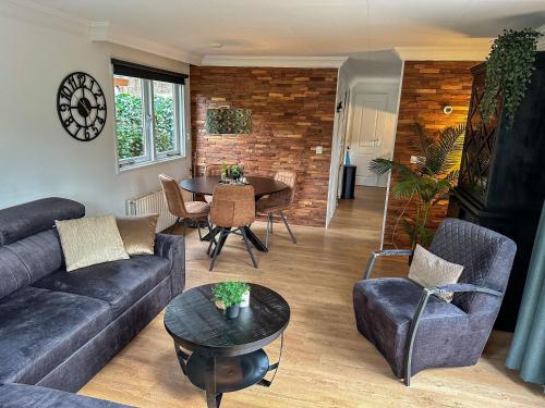 een woonkamer met een bank en een tafel bij Bos chalet “relaxed” in Doornspijk