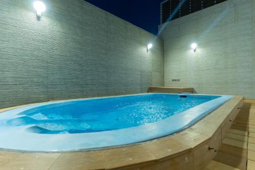 bañera de hidromasaje grande en una habitación con luces en Rasia Hotel Jeddah, en Yeda