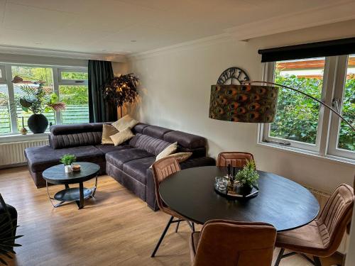 een woonkamer met een bank en een tafel bij Bos chalet “relaxed” in Doornspijk