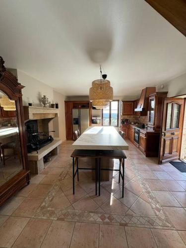 une grande cuisine avec une table au milieu dans l'établissement Maison au Bord de la Falaise, à Baubigny