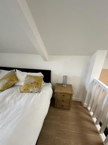 a bedroom with a white bed and a wooden night stand at The Highmead in Blackwood