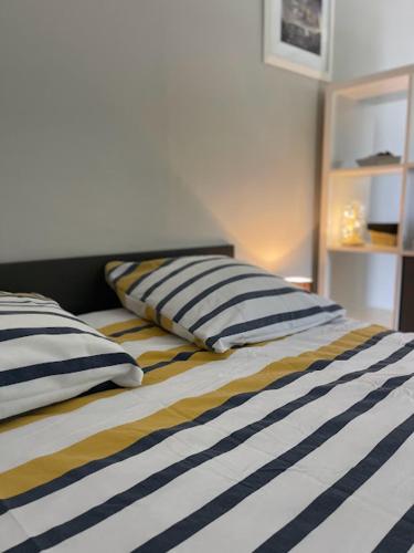 un lit avec deux oreillers dessus dans l'établissement Les hyacinthes 2, à Sarlat-la-Canéda