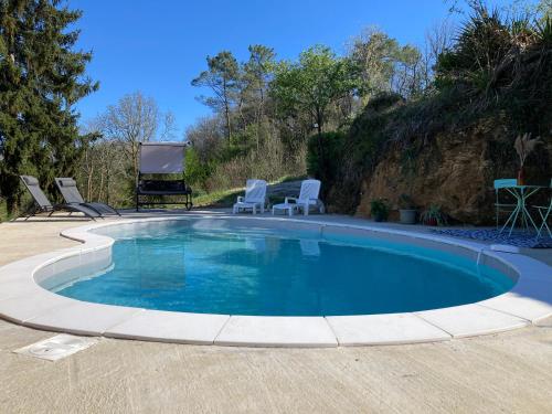 einen Pool mit zwei Stühlen in der Unterkunft Les hyacinthes 2 in Sarlat-la-Canéda