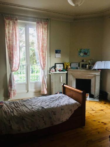 - une chambre avec un lit, une cheminée et une fenêtre dans l'établissement Villa à Corenc, famille 6 pers, à Corenc