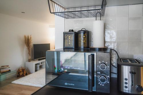 a microwave oven sitting on top of a counter at Maison Zola in Fleury-les-Aubrais