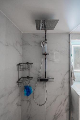 une douche avec une porte vitrée dans une salle de bain dans l'établissement Maison Zola, à Fleury-les-Aubrais