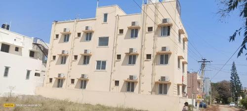 un gran edificio blanco con ventanas laterales en The Grand Stays codissia, en Coimbatore