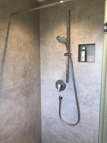 a shower with a shower head in a bathroom at feelslikehome Apartment Nähe Stuttgart Flughafen - Messe in Filderstadt