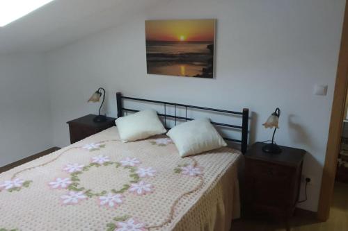 a bedroom with a bed with two pillows at Gala T1+ in Figueira da Foz