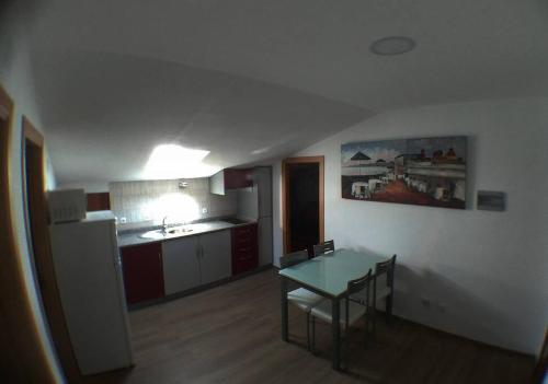 a kitchen with a table and chairs in a room at Gala T1+ in Figueira da Foz