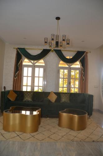 a living room with a couch and two gold tables at Urti Villa in Nzala