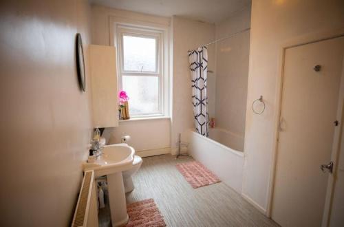 een badkamer met een wastafel, een toilet en een raam bij Cozy Room @ Wallsend in Old Walker