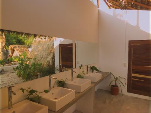 La salle de bains est pourvue de 4 lavabos et d'un miroir. dans l'établissement TRIBU Glamping & beach view, à Puerto Escondido